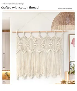 Detail of hand-woven cotton macrame wall hanging with bohemian fringe and wooden rod