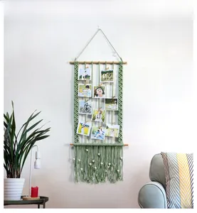 Close-up of Nordic sage green macrame photo wall hanging with wooden clips and tassels
