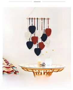 Détail de tapisserie murale en macramé avec feuilles tissées colorées et perles de bois