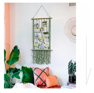 Detail of bohemian handmade cotton rope wall photo organizer with tassels and wood clips