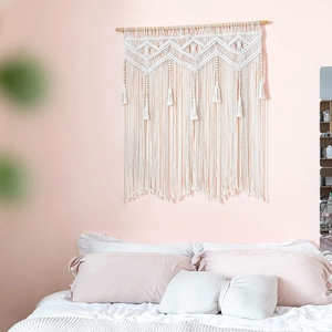 Detail of bohemian hand-woven wall tapestry with geometric diamond patterns and fringe