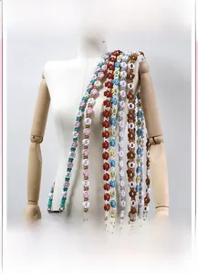 Detail of hand-woven cotton daisy lanyards with metal clips and colorful floral patterns