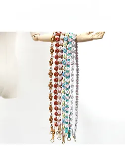 Detail of handmade woven daisy lanyard with golden metal lobster clasp and flower charms