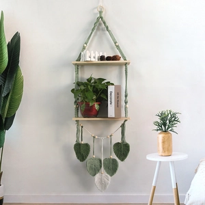 Detail of bohemian dual-tier woven wall shelf with green cotton rope and wooden beads