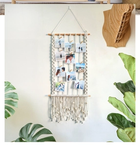 Detailed view of bohemian hand-woven macrame photo wall hanging with mini wooden clips