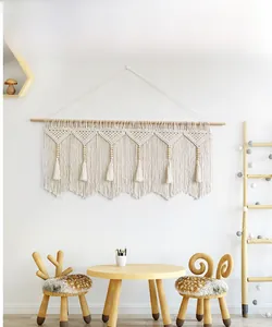 Close-up of bohemian hand-woven tapestry featuring geometric cotton knots and wooden beads