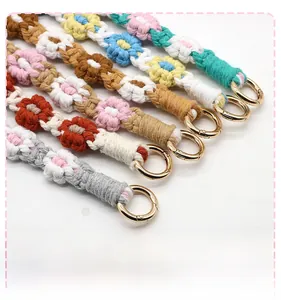 Close-up of handmade woven daisy lanyard straps with gold metal ring attachments