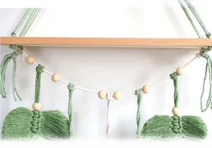 Detail of bohemian wall shelf with handmade green cotton rope and wooden bead tassel