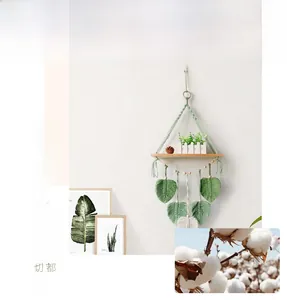 Detailed macro view of green bohemian hand-woven macrame wall shelf with leaf tassels