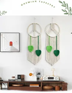 Detail of bohemian handmade wall hanging with woven green leaf tassels and wooden frames