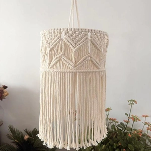 Detailed macro view of handmade macrame lamp shade with diamond patterns and long tassels