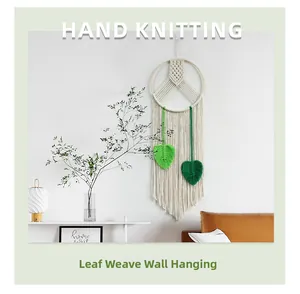 Detailed hand-knitted macrame wall hanging with green leaf patterns and cotton tassels