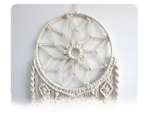 Detail showing the intricate handmade geometric star weave on white cotton wall hanging