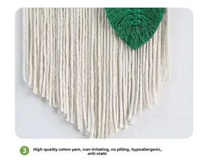 Detailed macro view of bohemian hand-woven cotton fringe and a green leaf macrame element
