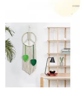 Detail of bohemian cotton rope tapestry with green leaves and a circular wooden frame