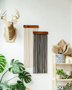 Detail view of woven cotton rope tassels on a wooden bar for bohemian wall decor
