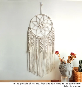 Detail of bohemian handmade cotton dream catcher wall hanging with woven star pattern and fringe