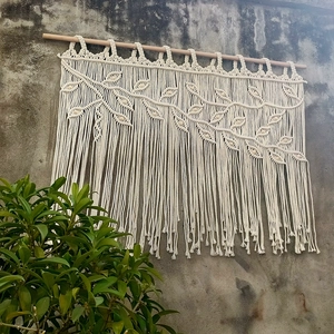 Detailed view of bohemian hand-woven tapestry with leaf pattern and tassel fringes