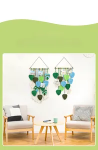 Detail of bohemian woven leaf wall hanging with wooden beam and photo clips