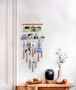 Detailed close-up of Bohemian hand-woven macrame wall hanging with wooden photo clips