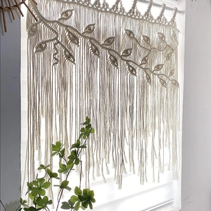 Handmade Bohemian macrame wall hanging with leaf pattern and tassels in off-white cotton