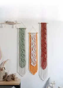 Detail of bohemian macrame leaf wall hanging with cotton fringe and wood rod