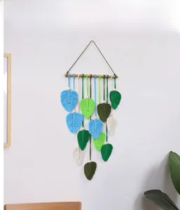 Detail of handmade macrame wall hanging with colorful woven leaves and wooden beads