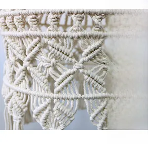 Close-up of handmade macrame lampshade with bohemian geometric weaving and cotton fringe