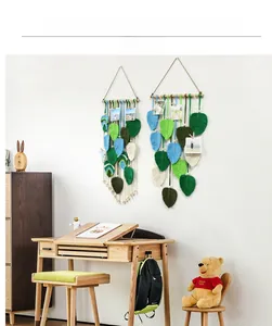 Detail of bohemian hand-woven leaf macrame wall hanging with wooden beads and photos