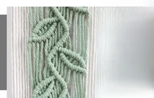 Close-up of bohemian leaf pattern handmade cotton woven tapestry in sage green and cream