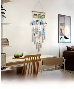 Close-up detail of Bohemian woven cotton tapestry photo display with wooden clips and tassels