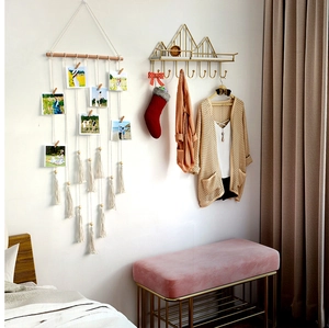Detail of bohemian woven macrame photo holder and golden mountain wall shelf with hooks