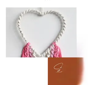 Close-up of bohemian handmade woven heart wall hanging with intricate cotton rope knot details