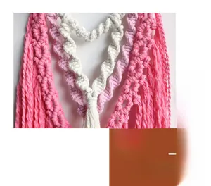 Detail of bohemian three-tier macrame heart wall hanging with pink and purple cotton tassels