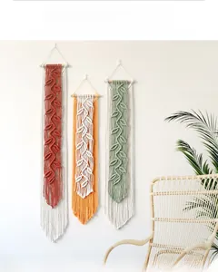 Detail of three handmade bohemian leaf macrame wall hangings in sage green and rust red