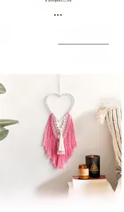 Detail of bohemian handmade macrame heart wall hanging with pink and white fringe tassels