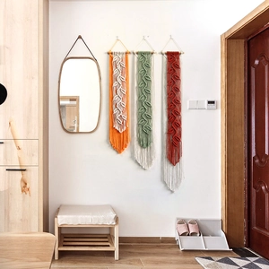 Handmade bohemian macrame wall hanging with leaf patterns and tassels in warm autumn tones