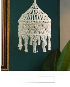 Detail of bohemian handmade cotton woven lampshade with fringe decor on a vintage wall