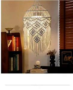 Detail of bohemian hand-woven cotton rope lampshade with tiered tassels and warm lighting