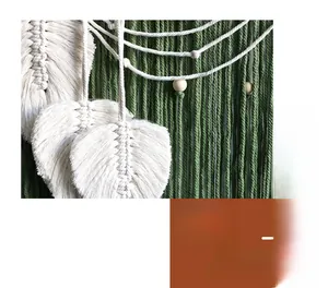 Close-up of hand-woven macrame wall hanging featuring cotton leaf tassels and wooden beads