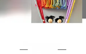Detail eines handgefertigten Regenbogen-Wandteppichs mit bunten Baumwollseilen und Holzpuppen