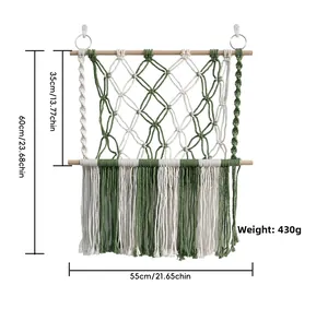 Detail of handmade macrame wall hanging with green tassels and wooden rods, 55cm width