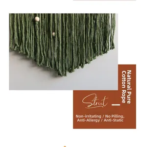 Detail of bohemian leaf tapestry featuring dark green cotton ropes and light wood beads