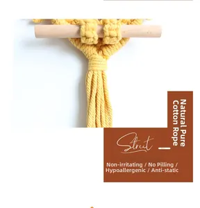 Detail of yellow cotton rope weave featuring boho tassels and smooth wooden rod