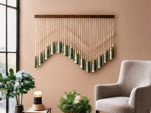 Detail of bohemian wall hanging with green tassels and wooden beads on a dark wood rod