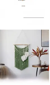 Detail of green macrame wall hanging with handmade white leaf tassels and wooden rod