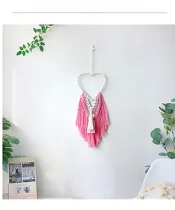 Detailed close-up of handmade Bohemian macrame wall hanging with pink layered tassels