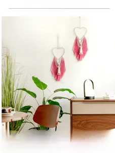 Detail of pink cotton macrame heart wall hanging with layered long tassels