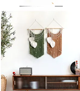 Detail of bohemian woven macrame wall hangings featuring leaf fringe and wooden beads
