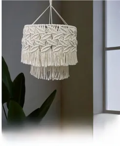 Detailed close-up of bohemian hand-woven cotton lamp shade with leaf patterns and tassels